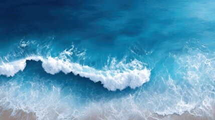 Fototapeta premium Aerial view of tranquil ocean waves gently lapping against a sandy shore, showcasing vibrant shades of blue and white foam.