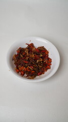Sambal Embe, a typical Balinese chili sauce, Indonesia, served on a white plate with a white base (isolated white).