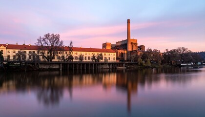 Obraz premium Sunrise over a riverside factory