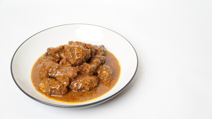 Beef stew is beef stewed with soy sauce and spices, served on a white plate with a white base and background.