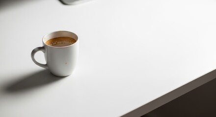 A warm cup of coffee on a white desk.