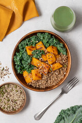 Autumn Harvest Bowl with Quinoa, Green Buckwheat, Roasted Pumpkin, and Kale in Wooden Bowl on Light Background. Healthy Vegan Fall Meal