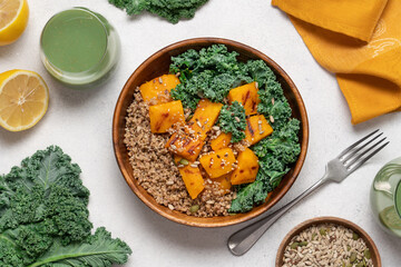 Autumn Harvest Bowl with Quinoa, Green Buckwheat, Roasted Pumpkin, and Kale in Wooden Bowl on Light Background. Healthy Vegan Fall Meal