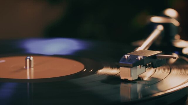 Retro Vinyl record player playing music, close-up macro shot of vintage LP disc old phonograph spinning. Retro music player at home.