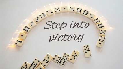 Creative Art Arrangement of Dominoes with Step into Victory Text