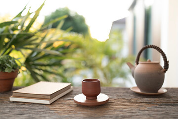 Old brown ancient earthenware tea set and notebook on wooden table