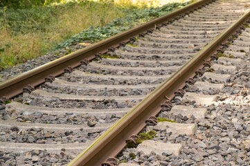 Naklejka premium Rusty train tracks disappearing into the distance on a sunny day