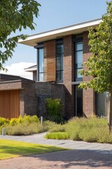 This contemporary brick home is beautifully enhanced with vibrant landscaping and features expansive windows, all nestled in a bright, sunny suburban area