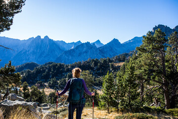 Naklejka premium Young hiker woman in autumn in Aiguestortes and Sant Maurici National Park, Spain
