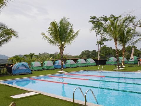 Scenic Outdoor Camping Site with Swimming Pool and Colorful Tents - Powered by Adobe