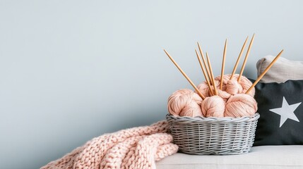 A person sits on a sofa, engaged in knitting with soft gray yarn and needles, surrounded by a pastel pink blanket in a warm, inviting living room
