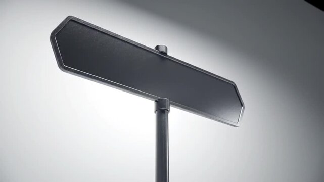Close-up shot of a blank, black, directional signpost with a simple design.