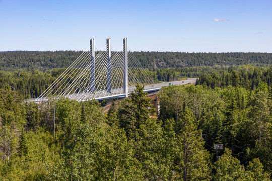 View of the Nipigon Bridge from a lookout tower, showcasing its cable-stayed design amid lush Ontario forests.