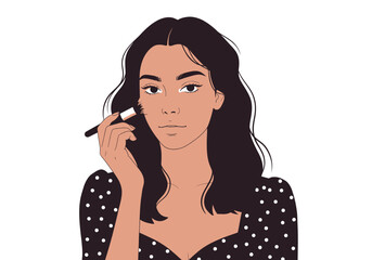 Obraz premium A woman with dark hair and a dotted dress applies makeup with a brush on her cheek