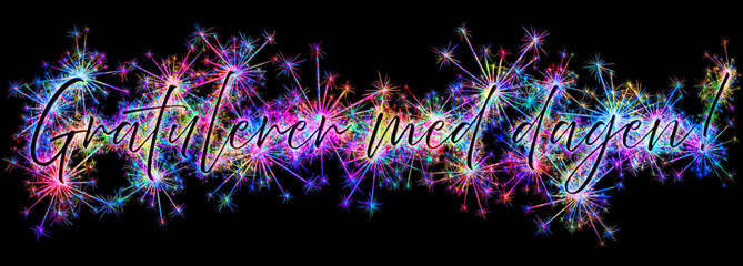 Kolorowe zimne ognie i fajerwerki układające się w kształt słów i życzeń Gratulerer med dagen!  (HAPPY BIRTHDAY) w języku norweskim.
