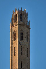 Fototapeta premium Vertical view of the Gothic tower of the Old Cathedral of Lleida in Catalonia illuminated by the sun against a clear sky