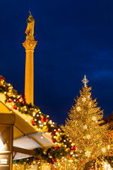 Naklejka premium Marian column and christmas tree illuminating the blue hour in Prague Old Town Square