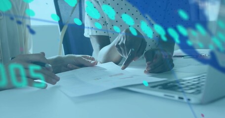 Pointing mid adult women analyzing printed bar chart report at office meeting room, with laptop pen