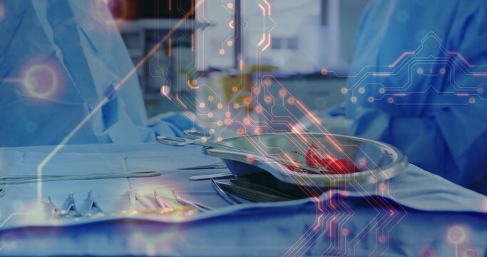 Overlaying circuitry in OR on tray with drape and kidney dish with tissue gowned surgeons observing