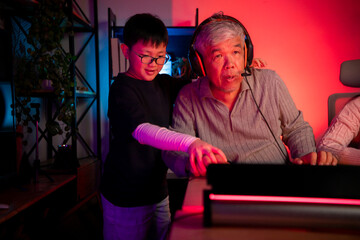Happy grandparents playing games with grandchildren in in a neon lit room