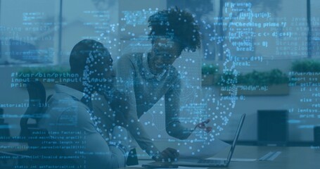 Colleagues wearing business attire reviewing code on laptop at table in office, amid code streams