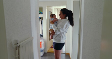 Mother holding baby in hallway near closet, natural light, cozy home, intimate family moment, nurturing and bonding in domestic setting