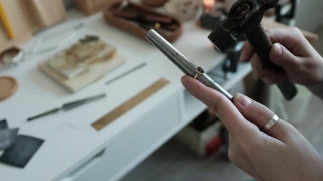 Closeup of a skilled female jeweler polishes ring detail. Small business craftsmanship in a bright modern workshop. The detailed process of traditional jewelry making. Artisan woman.