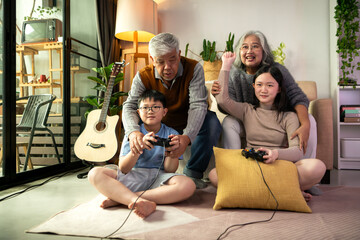 Happy grandparents playing video games with grandchildren in a cozy living room