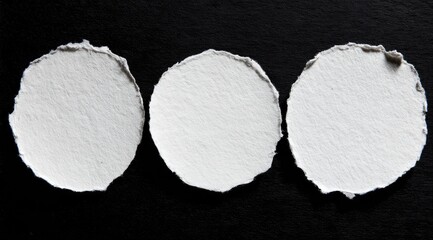 Three circular white paper cutouts on black backdrop