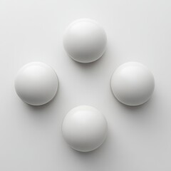 Four white spheres arranged in a cross pattern on a plain white background.  Geometric, minimalist design.  Perfect spheres, smooth surfaces.  Clean, modern aesthetic