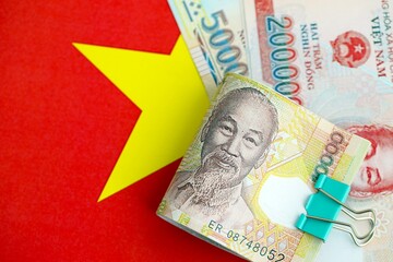 Vietnamese dong currency money bills lies on flag. The concept of business and investment