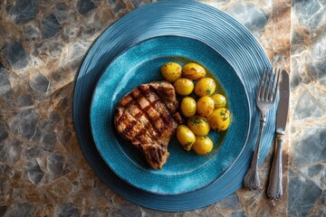 Grilled pork chop with roasted potatoes on a teal plate (1)