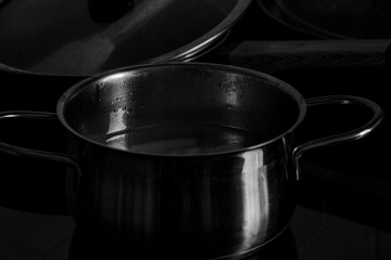 Gleaming metal pot on a dark background.