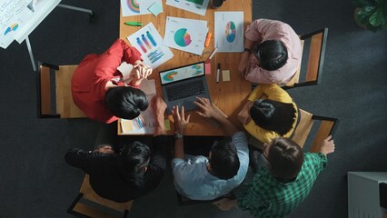 Top view of business team looking at laptop and analyzing chart. Close up of diverse group working on computer and reading financial report. Group of people explain idea at meeting. Convocation.