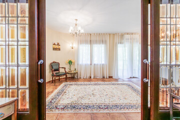The front hall of the house with furniture and a view of the corridor, with the feeling of bright sunshine outside.
