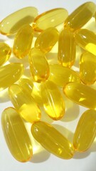 Fototapeta premium Yellow capsules on white background (1)