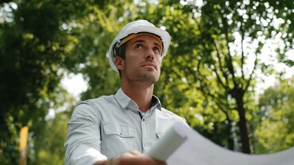 Architect with a Blueprint: A determined architect, wearing a protective hard hat, thoughtfully examines blueprints, symbolizing architectural planning and the pursuit of engineering excellence.