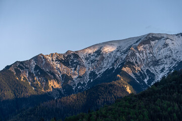 snow covered mountains tatry poland with clouds around and big pine trees