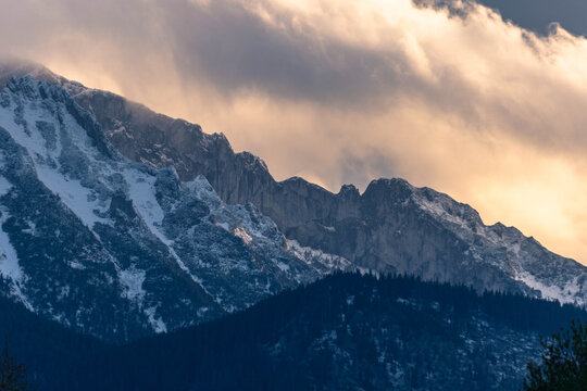 sunset beautiful light over rocky high snow covered mountains with cloudy sky landscape