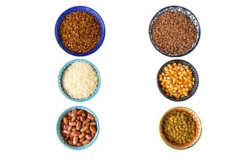 Top view of various grains and legumes in colorful bowls on a white background