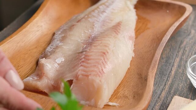 A fresh, raw cod fish fillet is served in a rustic wooden bowl. Perfect for concepts of healthy eating, seafood recipes, restaurant menus, and culinary content