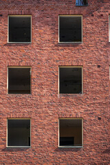 Closeup of red brick building wall windows.