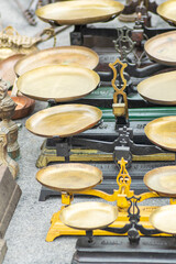 A collection of antique brass and iron balance scales at a flea market The Concept of Justice and Balance