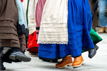 The feet and skirts of a group of folk dancers in traditional costumes The Joyful Movement of a Cultural Tradition