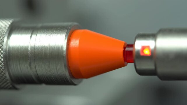 Industrial Proximity Sensor Close Up - Close-up view of an industrial proximity sensor featuring an orange tip and a red indicator light.
