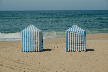 Traditional Blue and White Beach Cabins on Sandy Shore