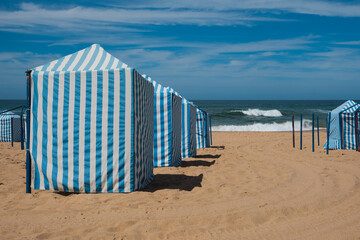 Traditional Blue and White Beach Cabins on Sandy Shore