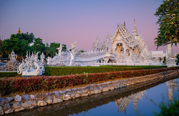 Fototapeta premium Stunning white temple wat rong khun at sunset in Chiang Rai, Thailand