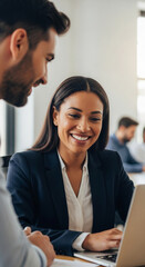 Smiling businesswoman works on laptop, collaborating with colleague, showcasing successful teamwork and professional collaboration in modern office environment