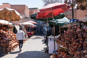 Man strolls through a vibrant moroccan market in marrakech, browsing stalls filled with colorful pottery and local crafts